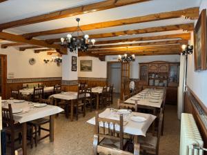 a restaurant with wooden tables and chairs in a room at El Refugio Valdelinares Gastro Hostal in Valdelinares