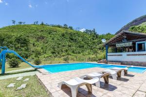 a swimming pool with a slide next to a house at Pousada Pedra de Paraibuna in Comendador Levy Gasparian +17 photos