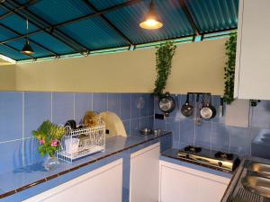 a kitchen with blue tiled walls and a counter top at Surya Pandawa Homestay in Uluwatu