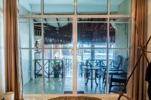 a room with a large window with a table and chairs at We Are Surfers Hotel in Weligama