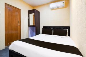 a bedroom with a white bed with a brown door at Hotel O BIJAY HOMES in Bhubaneshwar
