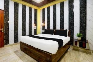 Dormitorio con cama con pared de rayas en blanco y negro en HOTEL O ELEGANT, en Prayagraj