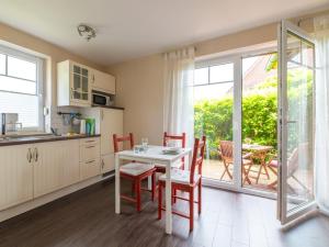 Una cocina con mesa y sillas y una ventana. en Ferienwohnung Kleiner Vilm, en Putbus