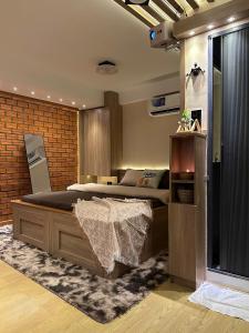 a bedroom with a large bed and a brick wall at Tom's House 270 in Ho Chi Minh City