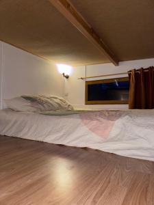 a bed in a small room with a window at Tiny house au coeur de la foret in Les Martys