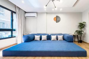 a large blue couch in a living room with a window at The 2BDR Obsidian Jacuzzi Stay 5min to CAI Airport in Cairo +14 photos