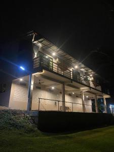 a house with a balcony at night with lights at Lipis Riverfront Resort in Kuala Lipis