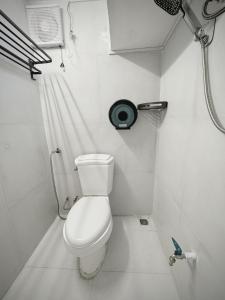a small bathroom with a toilet and a shower at Truman Hostel in Luang Prabang