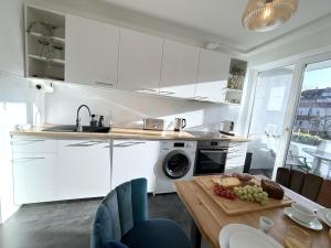 ブラウンシュヴァイクにあるMona Lisa, Komplette Wohnung, 24h Check-in, mit Parkplatz, Balkon, 2x Smart TV, Zentrumの白いキャビネットとテーブル(食べ物付)が備わるキッチン