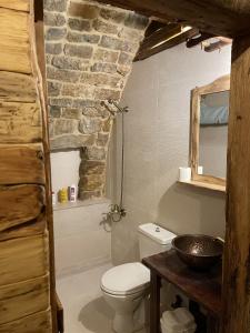 a bathroom with a toilet and a stone wall at Bayt Wadad, Bcharre Lebanon in Bcharré +32 photos