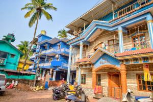 卡兰古特Hotel Savita Calangute的一座蓝色的建筑,前面停有摩托车