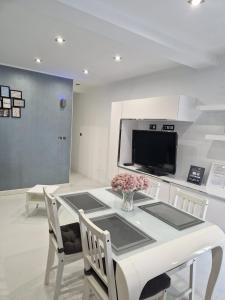 コミージャスにあるLa casita de Antonella - centro de Comillasのダイニングルーム(白いテーブル、テレビ付)