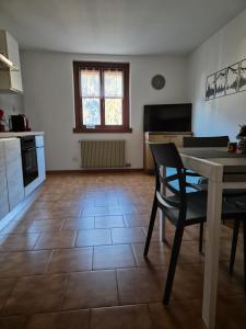 a kitchen with a table and a dining room at Snow Home Apartment - CIPAT 022093-AT-381181 in Giustino