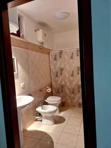 a bathroom with a toilet and a sink at Memela House in Poggio Mirteto +7 photos