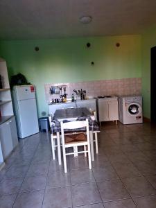 a kitchen with a table and a sink and a washing machine at Memela House in Poggio Mirteto