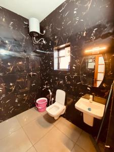 a bathroom with a toilet and a sink at The oro homestay in Ullāl