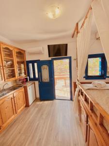 a kitchen with a blue door and a wooden floor at Emborios Views - Studio in Emborios