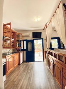 a kitchen with wooden floors and a blue door at Emborios Views - Studio in Emborios