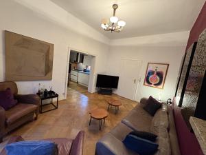 a living room with a couch and a tv at Geräumige 4-Zimmer-Wohnung im familienfreundlichen Westend mit Balkon in Frankfurt/Main