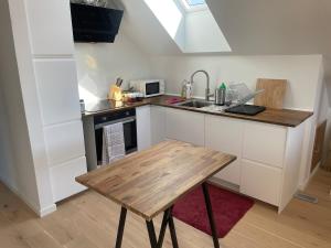 a kitchen with a wooden table and a sink at The Hidden Sea View in Sønderborg