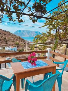 a wooden table with blue chairs and flowers on it at Emborios Views - Studio in Emborios