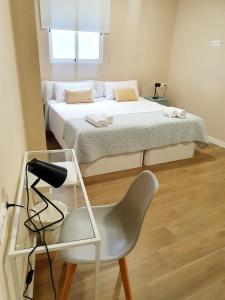 Un pequeño dormitorio con una cama y una silla. en Alegoría Coliving Experience, en Sevilla