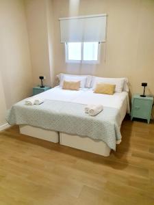 Un dormitorio con una cama grande con toallas. en Alegoría Coliving Experience, en Sevilla