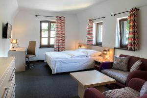 um quarto de hotel com uma cama e uma sala de estar em Zajazd Ryszkówka em Bestwina