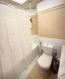 a white bathroom with a toilet and a shower at AlRaef Luxury Apartments in Dubai