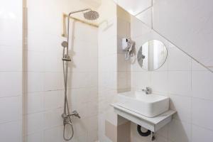 um banheiro branco com pia e chuveiro em Phan Hotel em Cidade de Ho Chi Minh mais 37 fotografias