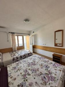 a bedroom with two beds with a floral bedspread at Heaven Apartments in Ulcinj
