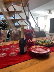 a bottle of wine sitting on a table with wine glasses at Erelia Cottage in Bük