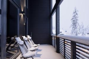 een veranda met twee banken bedekt met sneeuw bij Villa Aspen D Ski-in Ski-out by Aavalevi in Levi