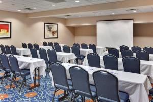 a conference room with tables and chairs and a screen at Holiday Inn Express & Suites Detroit - Novi by IHG in Novi +48 photos