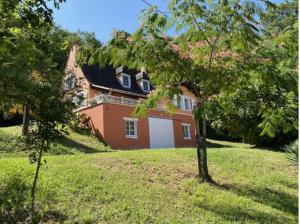 a house on a hill with a tree in the foreground at Le Petit Quintefeuille, Tennis in Journiac