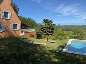 a house with a yard with a swimming pool at Le Petit Quintefeuille, Tennis in Journiac