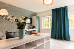 a living room with a table with a vase of flowers on it at Hus Mattgoot - Doppelzimmer No.2 in Böhl