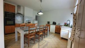 a kitchen with a table and chairs in it at La Grange Des Roches Roses in Anchenoncourt-et-Chazel