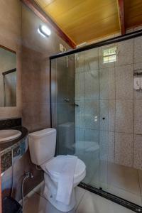 Un baño con inodoro y ducha de cristal. en Recanto Fiel, en Itacaré