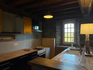 a kitchen with a counter and a sink and a window at Proche de la mer gite chez hippolyte in Surville