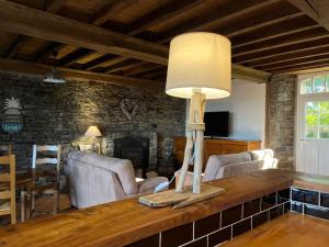 a living room with a table with a lamp on it at Proche de la mer gite chez hippolyte in Surville