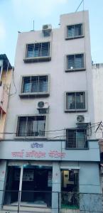 a tall white building with a sign on it at Arihant palace in Shirdi