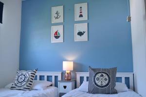 een slaapkamer met 2 bedden en een blauwe muur bij 46 Hectors, Sunbeach, Scratby - Two bed chalet, sleeps 4, pet friendly, free Wi-Fi, free entry to onsite clubhouse and bed linen and towels included in Great Yarmouth