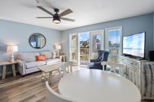 Grand Caribbean East 309 By Pkrm في بينساكولا: غرفة معيشة بها أريكة وطاولة