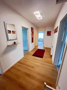 a hallway of an apartment with white walls and wooden floors at ferienwohnung natalie in Nickenich