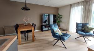 a living room with a table and chairs and a tv at Immer simmer in Lemmer