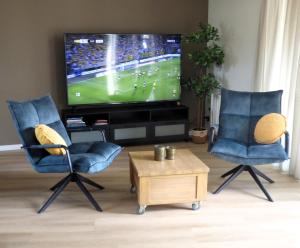 a living room with two chairs and a flat screen tv at Immer simmer in Lemmer