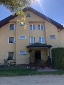 a large yellow house with a front door at Pensjonat Klaudia in Ostrowo