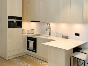 a kitchen with white cabinets and a sink at MrSTiL Design Aparthotel in Berlin