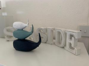 a figurine sitting in front of a sign that reads study at Pollywiggle Cottage, Dog Friendly cottage in Heacham in Heacham